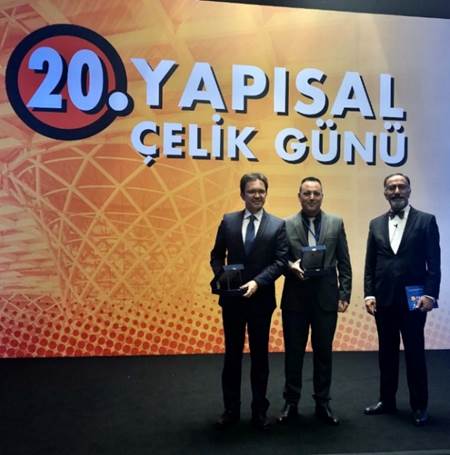 A group of people standing in front of a sign

Description automatically generated